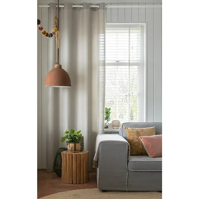 Elbersdrucke Ösenschal Lino - Taupe, 140 x 255 cm, 100 % Polyester - Ein gemütliches Interieur mit einem grauen Sofa, Zierkissen, Beistelltisch aus Holz und einer stilvollen Pendelleuchte. Natürliches Licht erhellt den Raum.