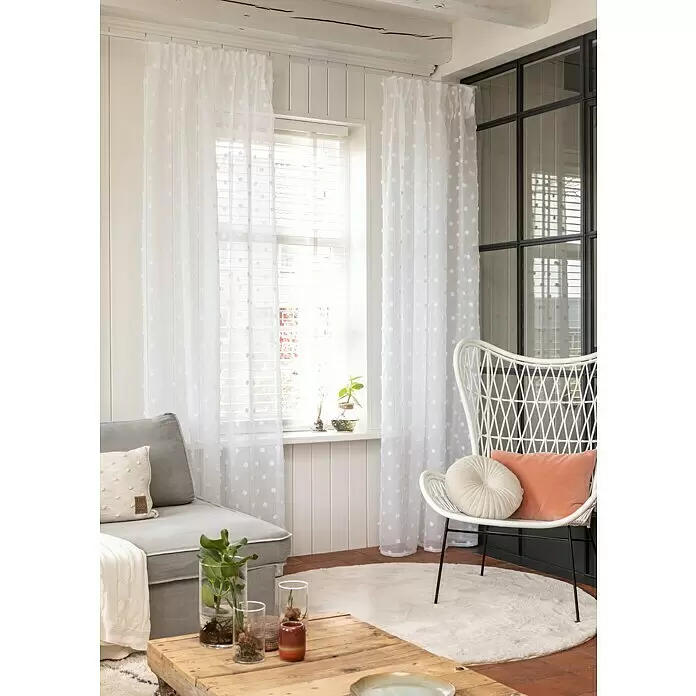 Elbersdrucke Schlaufenschal Fluffy Dots - Weiß, 100% Polyester - Weiße transparente Gardinen mit flauschigen Pompons, elegant vor einem Fenster hängend.