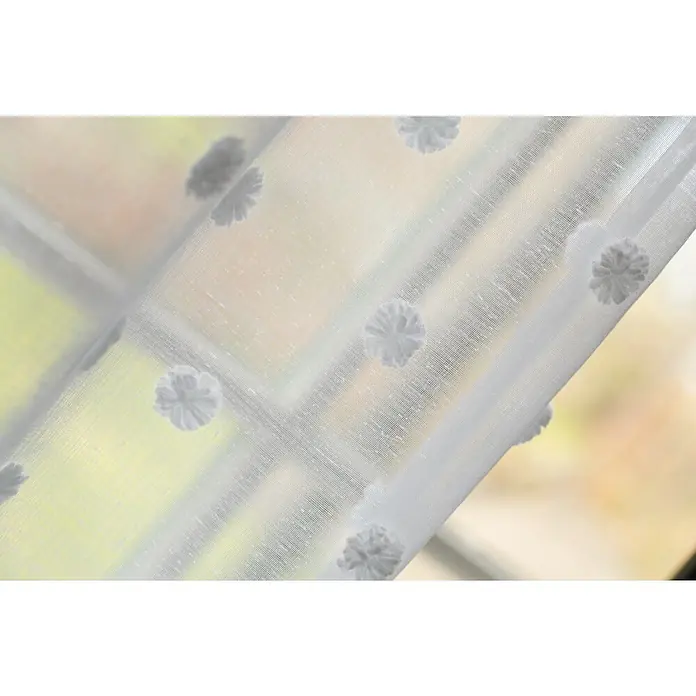Elbersdrucke Schlaufenschal Fluffy Dots - Weiß, 100% Polyester - Nahaufnahme eines weißen Voile-Fenstervorhangs mit zarten Blumenstickereien, der eine helle und luftige Atmosphäre schafft.