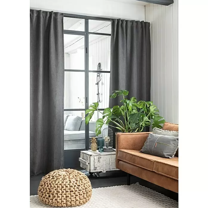 Elbersdrucke Verdunkelungsvorhang Monza - Dunkelgrau, 100% Polyester - Dunkelgrauer Vorhang aus strukturiertem Stoff, an einer Stange über Industrie-Fenstern in einem modernen Wohnzimmer aufgehängt.