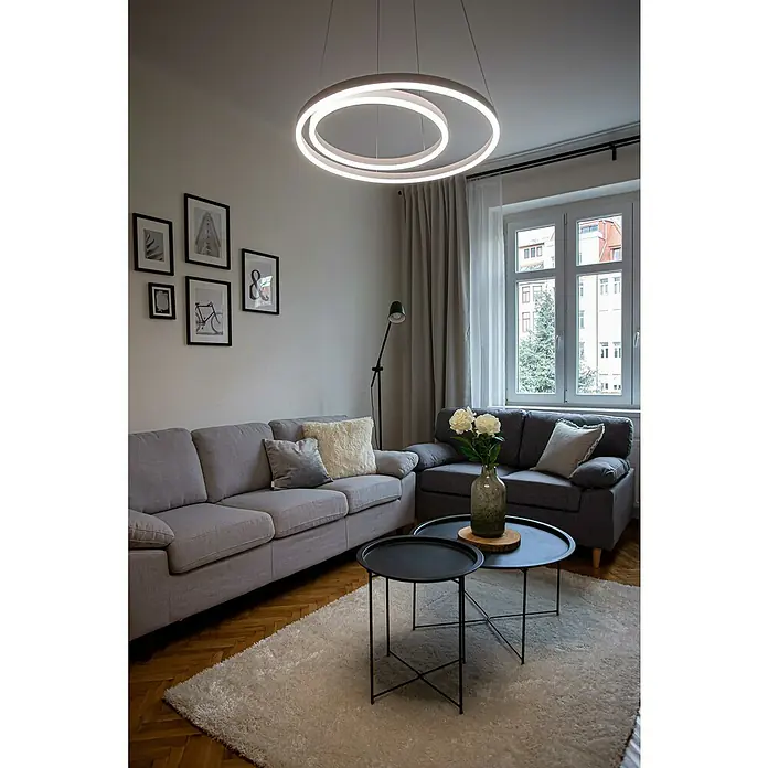 Direct Signs LED-Pendelleuchte Noble - Höhe: 150 cm, Weiß, Durchmesser: 600 mm - Ein helles Wohnzimmer mit einer modernen, kreisförmigen Hängeleuchte über einem grauen Sofa und einem hellen Teppich.
