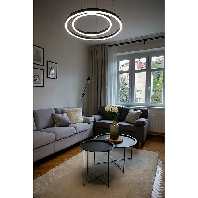 Direct Signs LED-Pendelleuchte Noble - Höhe: 150 cm, Schwarz, Durchmesser: 600 mm - Ein modernes Wohnzimmer mit einem auffälligen, runden LED-Deckenleuchter, der das Zimmer hell erleuchtet und für eine angenehme Atmosphäre sorgt.