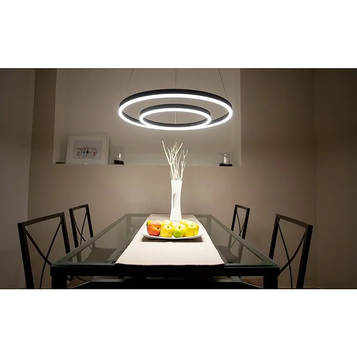 Direct Signs LED-Pendelleuchte Noble - Höhe: 150 cm, Schwarz, Durchmesser: 600 mm - Ein eleganter Esstisch mit einem modernen, kreisförmigen LED-Kronleuchter darüber, der den Raum hell erleuchtet.