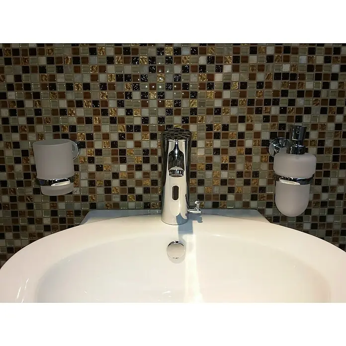 Mosaikfliese Quadrat Crystal Mix XCM M830 - 30,5 x 32,2 cm, Beige/Braun, Glänzend - Das Bild zeigt ein modernes Badezimmerwaschbecken mit Armatur, Seifenspender und Zahnputzbecher vor einer Mosaikwand.