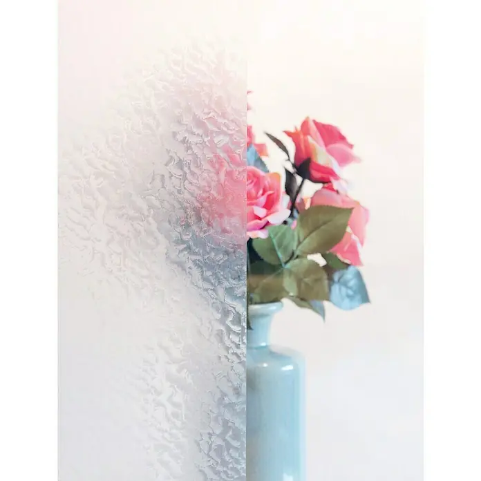 D-c-fix Static Premium Glasfolie Snow - 150 x 67,5 cm, Transluzent, Statisch haftend - Nahaufnahme einer Vase mit rosa Rosen, zur Hälfte durch eine strukturierte Glasscheibe verdeckt, die das Bild interessant teilt.