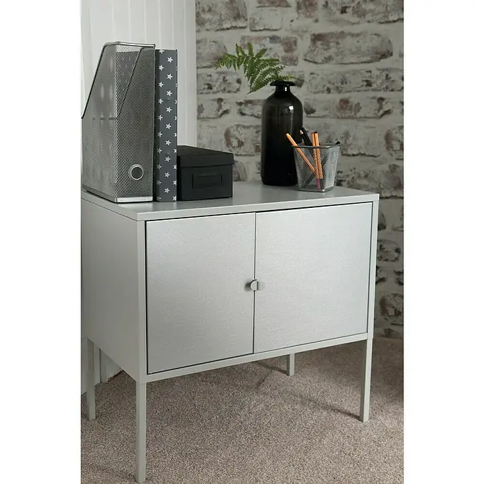D-c-fix Metalleffektfolie Metallic Brush - 150 x 67,5 cm, Silber, Selbstklebend - Silberner Schrank mit zwei Türen, verziert mit Büroaccessoires und einer Vase, ideal für Büro oder Zuhause.\n