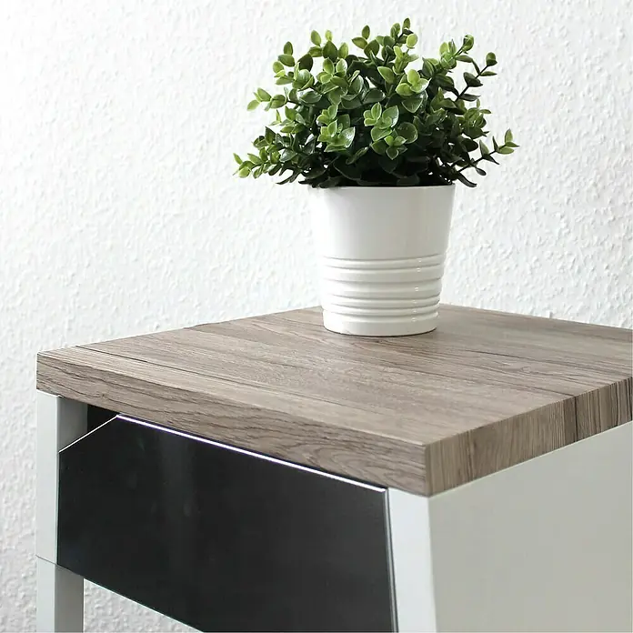 D-c-fix Holzoptikfolie Sanremo Eiche - 200 x 67,5 cm, Sepia, Selbstklebend - Nahaufnahme eines Nachttischs mit einer Holzplatte und einer kleinen Topfpflanze.
