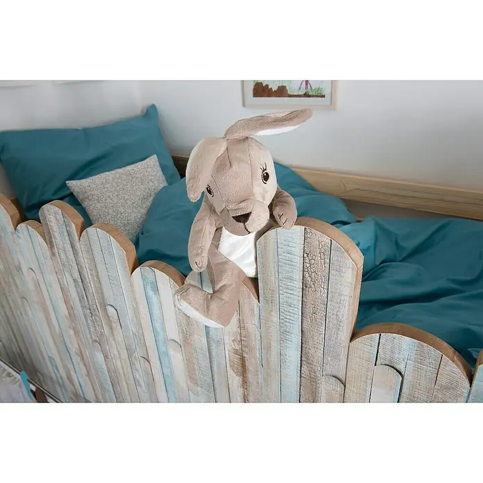 D-c-fix Dekore Holzoptikfolie Rio - 200 x 67,5 cm, Ocean, Selbstklebend - Kuscheltierhase auf einem Kinderbett mit blauem Bettzeug und einem Lattenzaun-Design, das dem Kinderzimmer eine warme Note verleiht.