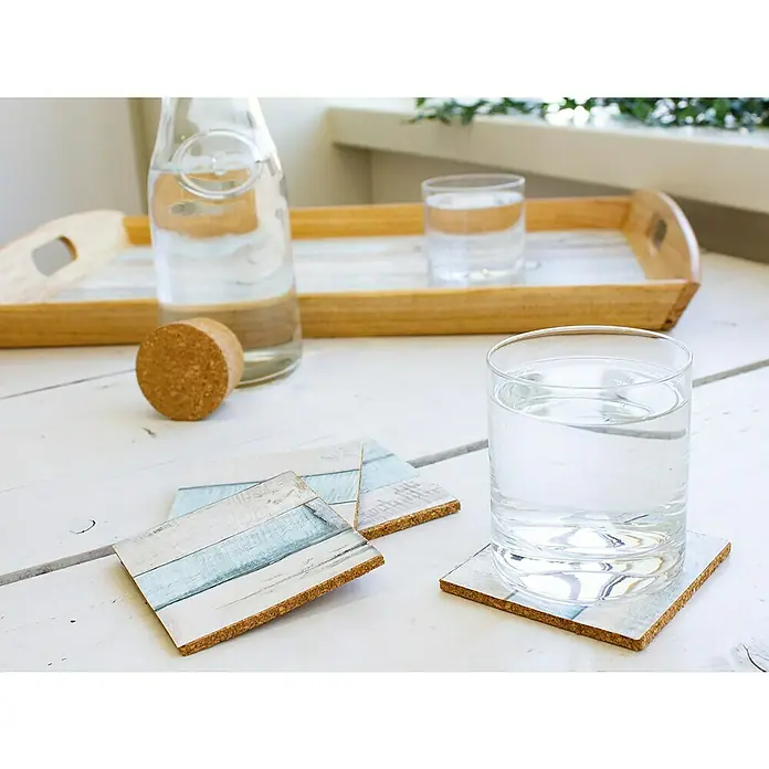 D-c-fix Dekore Holzoptikfolie Rio - 200 x 67,5 cm, Ocean, Selbstklebend - Eine erfrischende Wasserflasche und ein Glas Wasser, präsentiert auf einem Tablett mit dekorativen Untersetzern.