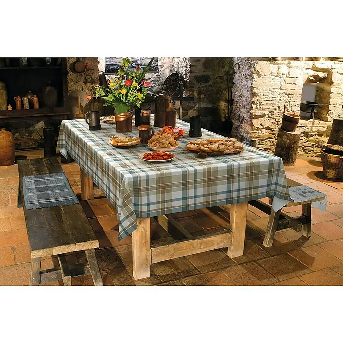 D-c-fix Manhattan Tischdecke Meterware Borneo - Breite: 140 cm, Blau - Ein rustikaler Tisch mit karierter Tischdecke, beladen mit Speisen, umgeben von Holzbänken in einem gemütlichen, historischen Ambiente.