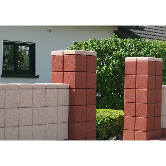Christoph Mauerabdeckplatte Ambienta - 40 x 20 x 5 cm, Mediterran, Beton - Nahaufnahme von Ziegelmauerwerk mit dekorativen Ziegelpfeilern und einem Fenster im Hintergrund, umgeben von üppigem Grün.