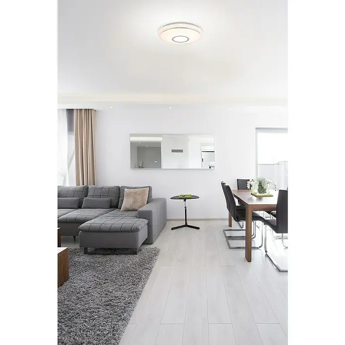 Lavida LED-Deckenleuchte rund Solesino - 16 W, Ø x H: 400 mm x 8 cm, Weiß - Ein modernes Wohnzimmer mit einem grauen Sofa, einem Esstisch und einer runden Deckenleuchte, die eine gemütliche Atmosphäre schafft.