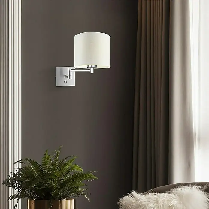 Home Sweet Home Swing Wandleuchte - 40 W, L x B x H: 27 x 27 x 10 cm, Stahl matt, E27 - Nahaufnahme einer modernen Wandleuchte mit zylindrischem Lampenschirm und silbernem Arm vor einer stilvollen Wand.