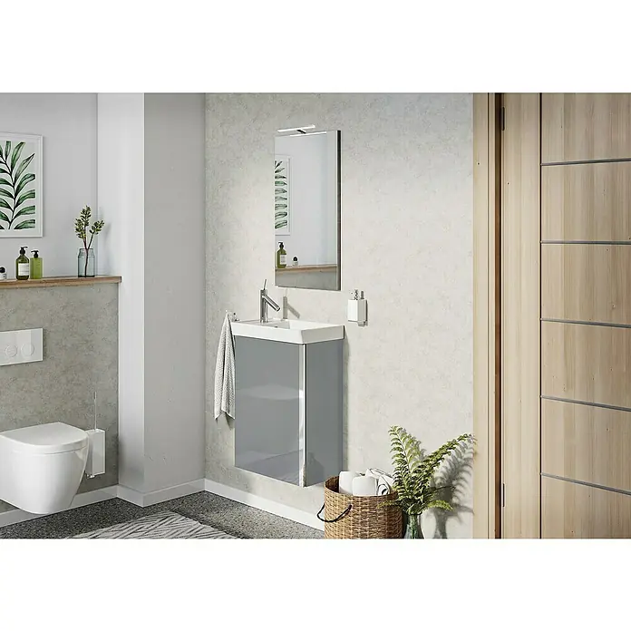 Riva Badmöbel-Set Joy - Gesamtbreite Badmöbel: 45,5 cm, Grau, Hochglänzend, 3 -tlg. - Ein modernes Badezimmer mit einem grauen Waschbeckenunterschrank, einem Spiegel und einer Toilette. Das Waschbecken ist minimalistisch gestaltet.