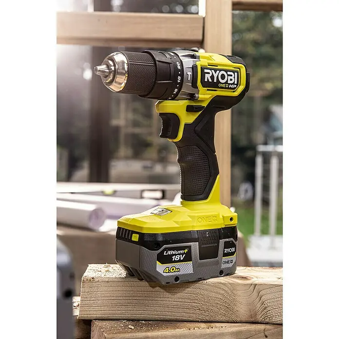 Ryobi ONE+HP Taladro atornillador percutor de batería RPD18C - 18 V, Sin batería, 0 Ah, 50 Nm - Primer plano de un taladro inalámbrico Ryobi ONE+ HP amarillo y negro con una batería de litio+ de 18 V sobre una tabla de madera.
