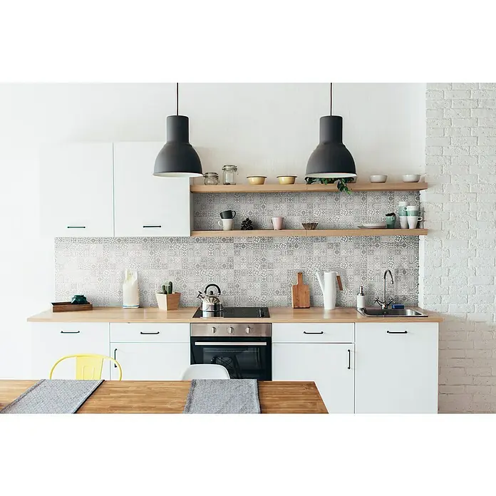 Malla mosaico Antic - 29 x 29 cm, Gris, Mate - Cocina luminosa con armarios blancos, encimeras de madera, azulejos estampados y dos lámparas colgantes negras.