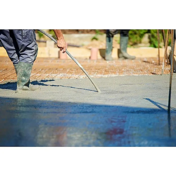 Berg Betonrüttler TBR 2000 - 2.000 W, 4.000 U/min - Ein Bauarbeiter verdichtet frischen Beton mit einem Vibrationsstampfer, um Lufteinschlüsse zu entfernen und die Festigkeit des Betons zu erhöhen.