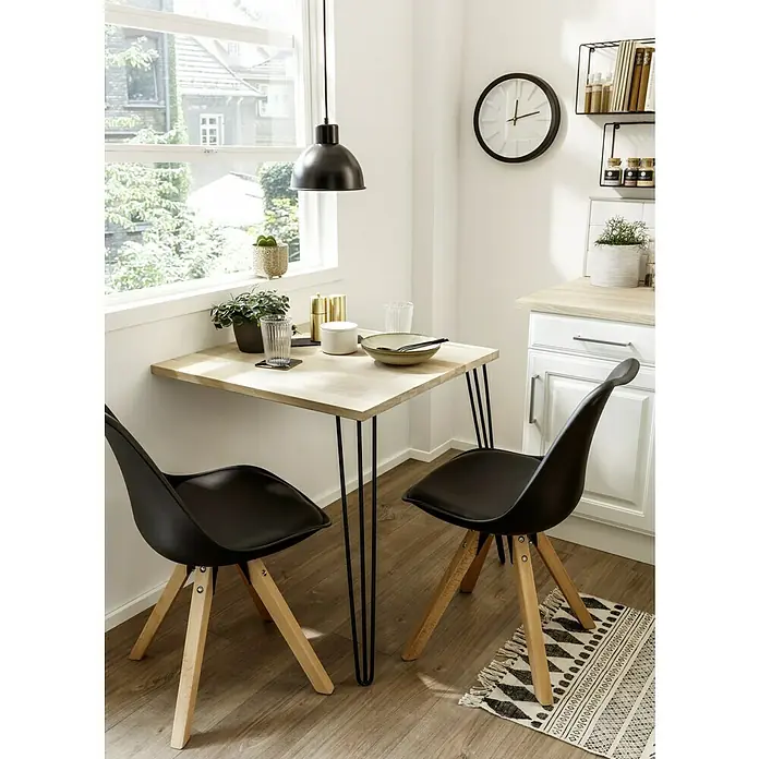 Tischplatte - Eiche, 70 x 70 x 2,6 cm - Ein moderner Essbereich mit einem quadratischen Holztisch auf schlanken Metallbeinen und zwei schwarzen Stühlen mit Holzgestell.