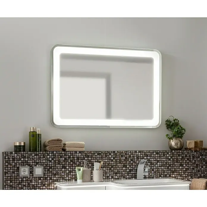 Camargue Stella LED-Lichtspiegel - 100 x 70 cm, Mit abgerundeten Kanten - Ein rechteckiger, beleuchteter Badezimmerspiegel hängt über einem Waschbecken, das eine moderne und stilvolle Badezimmerumgebung zeigt.