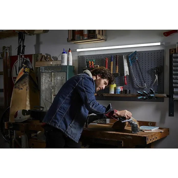 Osram LED-Lichtleiste Value Batten - L x B x H: 150 x 2,9 x 4,4 cm, Lichtfarbe: Kaltweiß, 24 W - Mann arbeitet in Werkstatt an Werkbank mit Werkzeugen und LED-Beleuchtung für optimale Sicht.