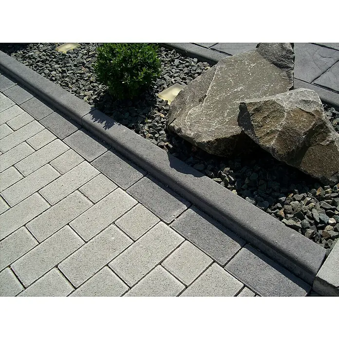 EHL Tiefbordstein - 100 x 30 x 8 cm, Anthrazit - Nahaufnahme von stilvollen Pflastersteinen in Grau, die in einem eleganten Fischgrätenmuster verlegt sind und einen modernen Außenbereich gestalten.