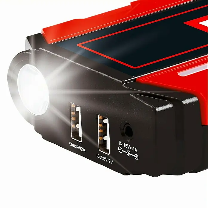 Einhell Kit de arranque CE-JS 12 - 12 V, Corriente máx. de carga: 400 A - Primer plano de un arrancador portátil con puertos USB y una linterna LED brillante.