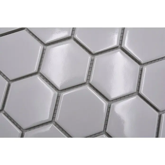 Mosaikfliese Hexagon Uni HX 080 - 32,5 x 28,1 cm, Weiß, Glänzend - Nahaufnahme von weißen, glänzenden Sechseckfliesen. Die Fliesen sind dicht aneinander gelegt und durch Fugenmasse getrennt.