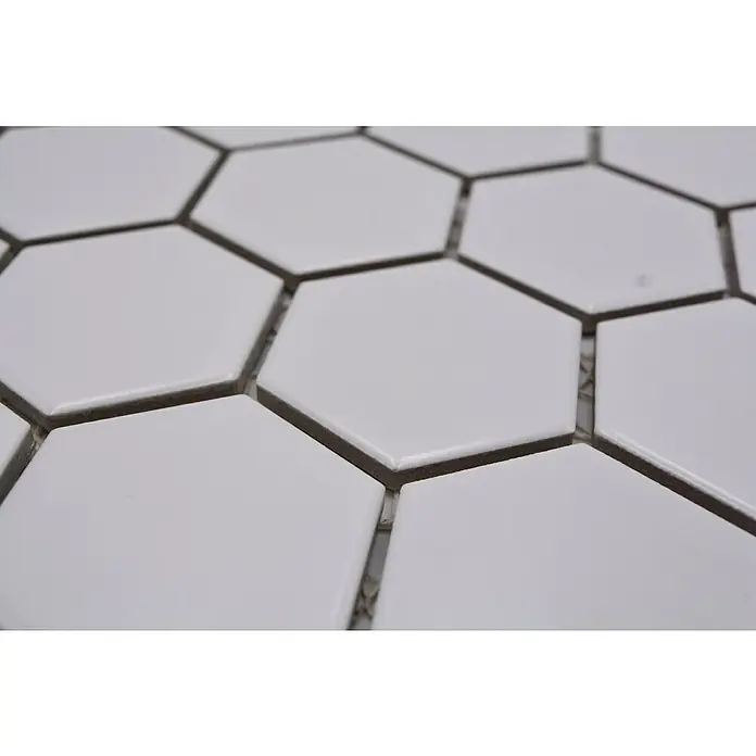 Mosaikfliese Hexagon Uni HX 085 - 32,5 x 28,1 cm, Weiß, Matt - Nahaufnahme von weißen Sechseckfliesen mit dunklen Fugen, die ein sauberes, modernes Muster auf einer Fläche bilden.