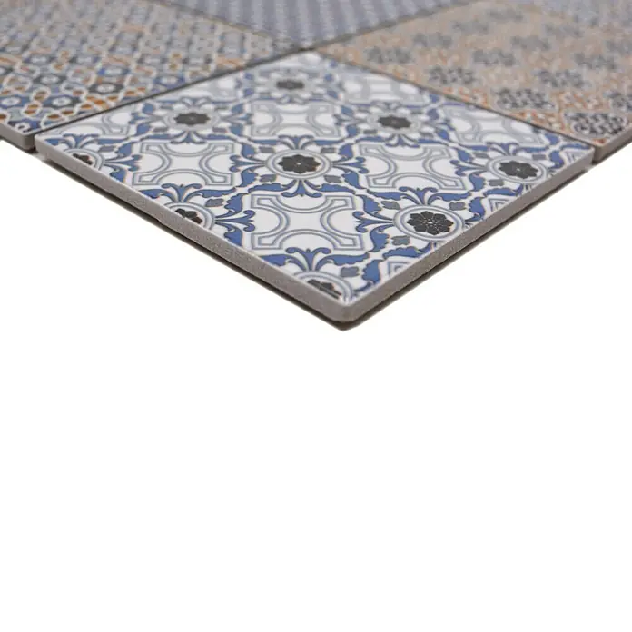 Mosaikfliese Quadrat Classico Mix - 29,8 x 29,8 cm, Mehrfarbig, Glänzend - Nahaufnahme von dekorativen Keramikfliesen mit floralen Mustern in Blau, Grau und Weiß, die ein stilvolles Designelement darstellen.