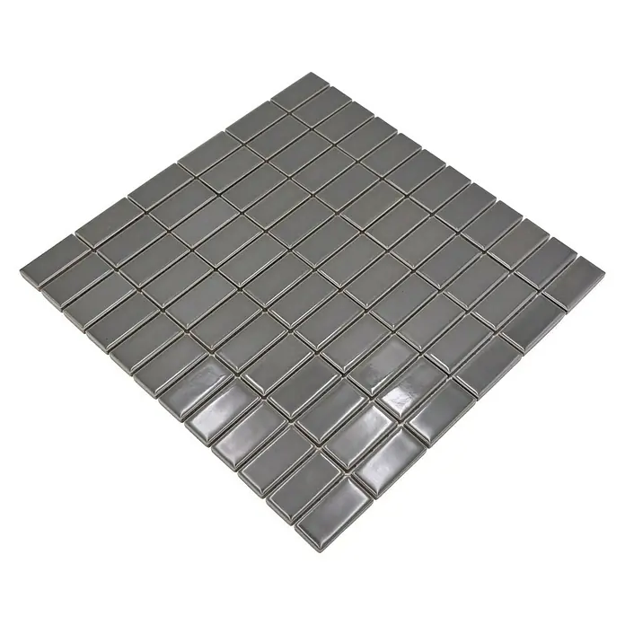 Mosaikfliese Stäbchen Uni ST 380 - 29,8 x 29,8 cm, Grau, Glänzend - Bild eines Mosaiks aus glänzenden, rechteckigen, grauen Fliesen auf einem schwarzen Hintergrund. Perfekt für moderne Wand- und Bodendesigns.