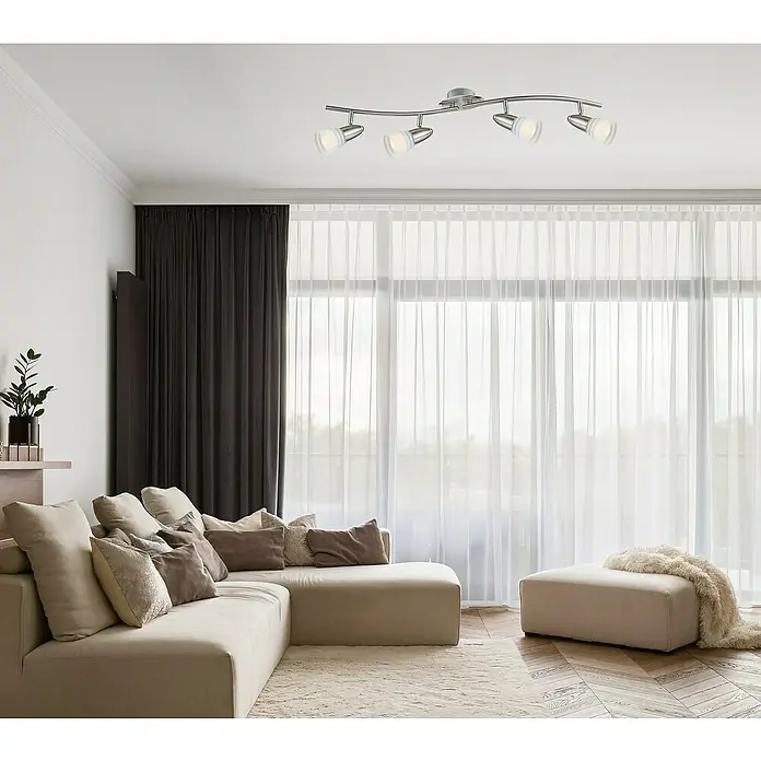 Globo Caleb LED-Wand- & Deckenstrahler - 12 W, Chrom, Opal, Warmweiß, 4 Stk. - Eine moderne Deckenleuchte mit mehreren Strahlern erhellt ein stilvolles Wohnzimmer mit Sofa, Vorhängen und Holzboden.