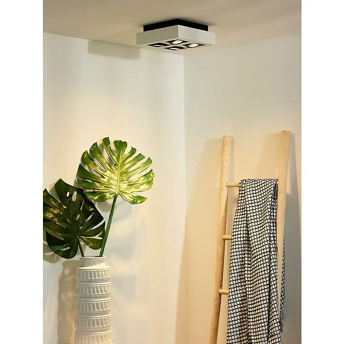 Lucide Plafón LED Xirax - 20 W, L x An x Al: 25 x 25 x 8,8 cm, Blanco, Blanco cálido - Lámpara de techo con cuatro focos en un interior moderno, complementado con plantas de interior y una escalera decorativa.