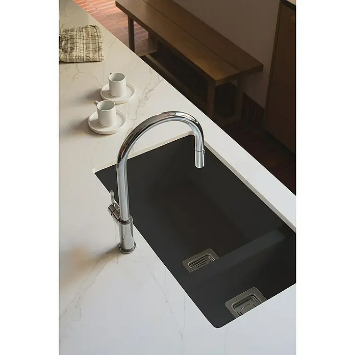 Poalgi Fregadero encastrable Zie Soft 70 - 45 x 75 cm, Material compuesto, Número de cubetas: 1,5 ud., Negro, Brillante - Vista de un fregadero moderno con grifo elegante y dos tazas blancas sobre una encimera de mármol.