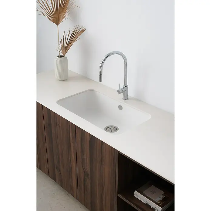 Poalgi Fregadero encastrable Gandía Soft 70 - 44,5 x 74 cm, Material compuesto, Blanco, Brillante - Primer plano de un fregadero de cocina moderno con grifo y dispensador, empotrado en una encimera blanca sobre un armario de madera.