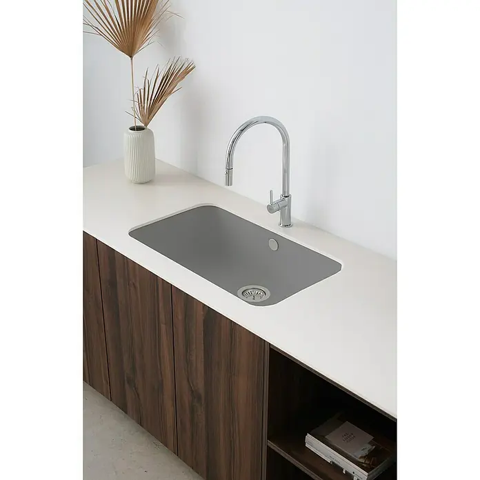 Poalgi Fregadero encastrable Gandía Soft 70 - 44,5 x 74 cm, Material compuesto, Concret, Brillante - Una cocina moderna con un fregadero de acero inoxidable y un grifo elegante, integrados en una encimera blanca con armarios de madera.