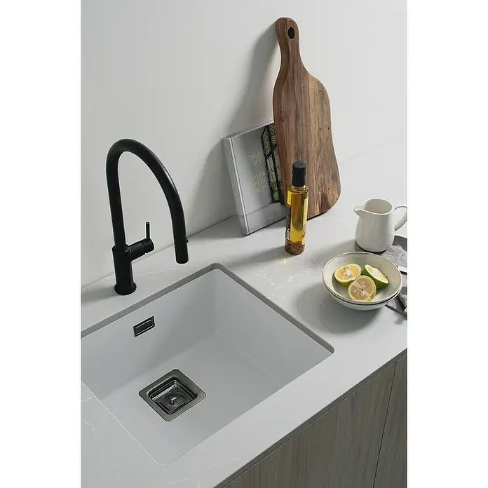 Poalgi Fregadero encastrable Zie Soft 45 - 45 x 50 cm, Material compuesto, Blanco, Brillante - Primer plano de un fregadero de cocina moderno con grifo, tabla de cortar y limón, mostrando un diseño elegante y funcional.