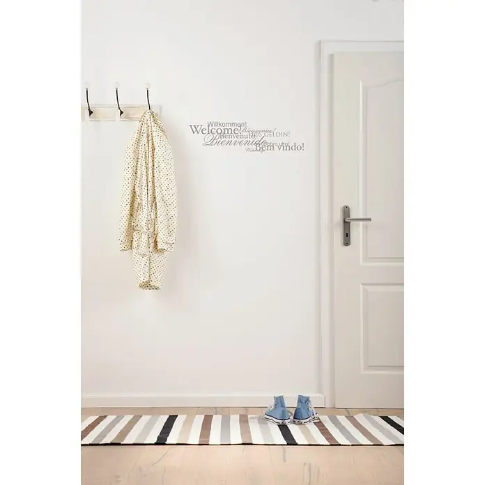 Komar Dekosticker Welcome - Silber, 50 x 70 cm - Einladender Flur mit Willkommensaufschrift, Garderobe, gestreiftem Teppich und blauen Schuhen, die eine warme und freundliche Atmosphäre schaffen.