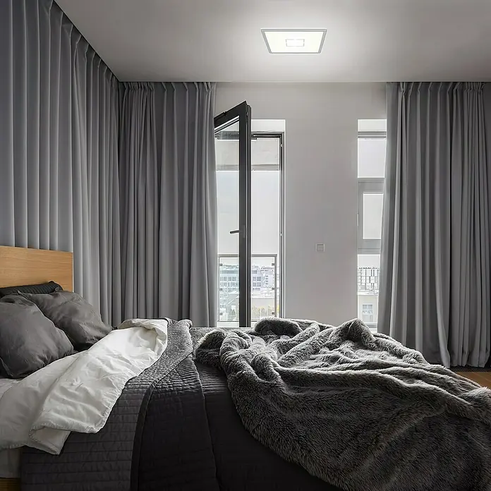 Tween Light LED-Deckenleuchte Montella eckig - 12 W, L x B x H: 19 x 19 x 2,8 cm, Weiß/Silber, Eckig - Schlafzimmer mit großem Bett, grauen Vorhängen und einer modernen, quadratischen Deckenleuchte. Die Lampe spendet helles Licht.