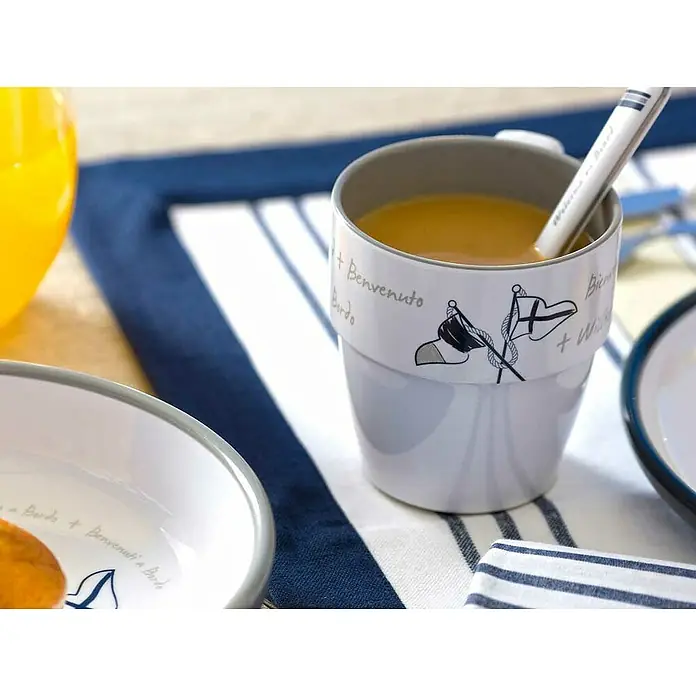 Marine Business Welcome on Board Taza para beber - 6 ud., Gris, 320 l - Primer plano de una taza náutica decorada con motivos náuticos, llena de una bebida y una cuchara a juego, expuesta sobre una mesa.
