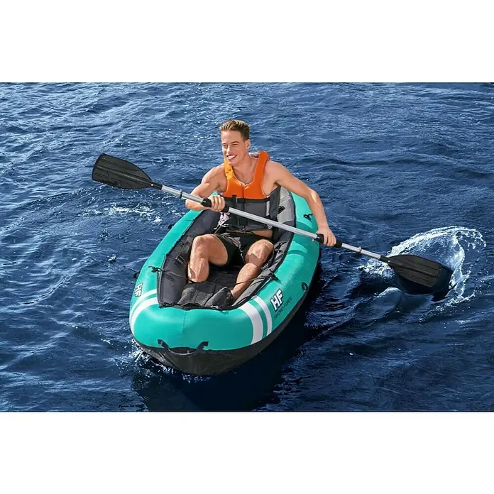 Bestway Hydro Force Kayak Ventura - Plástico, Turquesa - Un joven sonriente rema en un kayak Hydro-Force en el agua, equipado con chaleco salvavidas y remo.
