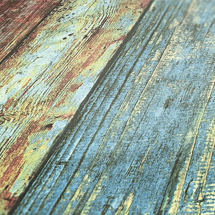 A.S. Création Elements Vliestapete - Bunt, Holzoptik, 10,05 x 0,53 m - Nahaufnahme eines Holzbodenmusters mit blauen, braunen und gelben Farbtönen, die eine rustikale und Vintage-Atmosphäre vermitteln.