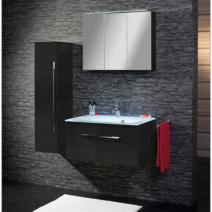 Camargue Stella LED-Spiegelschrank - B x H: 80 x 68,4 cm, Mit Beleuchtung, Dark Oak - Badezimmer-Set in modernem Design mit Waschbeckenunterschrank, Spiegelschrank und Hochschrank in dunkler Holzoptik vor einer Steinwand.
