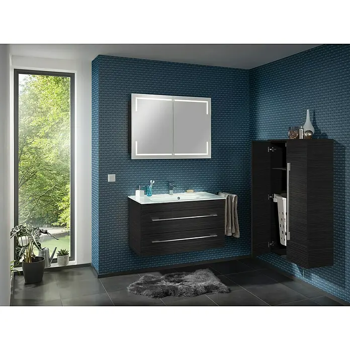 Camargue Stella LED-Spiegelschrank - B x H: 100 x 73,7 cm, Holz, Dark Oak, Mit Beleuchtung, Kantenausführung Tür: Eckig - Modernes Badezimmer-Interieur mit einem stilvollen Waschtisch mit Schubladen, beleuchtetem Spiegel und einem hohen Schrank an einer blau gefliesten Wand.