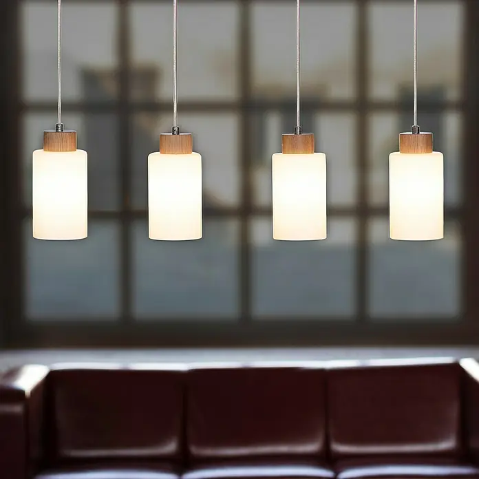 Spotlight Pendelleuchte Bosco60 W, L x B x H: 75 x 9,5 x 110 cm, Geölte Eiche/Transparent/Weiß, E27 - Eine Reihe moderner Pendelleuchten mit zylindrischem Lampenschirm, Holzakzenten und silberfarbenen Aufhängungen, die ein stilvolles Ambiente schaffen.