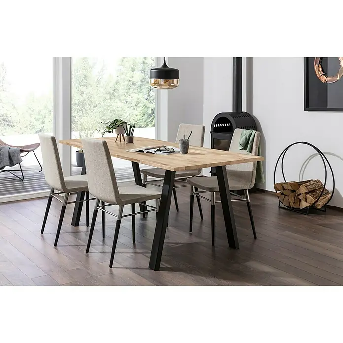 Exclusivholz Arbeitsplatte - Eiche, 400 x 80 x 3,8 cm - Ein Esstisch mit vier Stühlen steht in einem hellen Raum mit einem Kamin. Der Tisch hat eine helle Holzplatte und schwarze Beine.