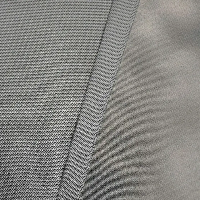 Verdunkelungsvorhang Dim - B x H: 135 x 245 cm, 100 % Polyester, Grau - Detailaufnahme eines grauen Stoffes mit unterschiedlichen Texturen, die eine interessante visuelle Tiefe erzeugen. Ideal für Mode und Design.