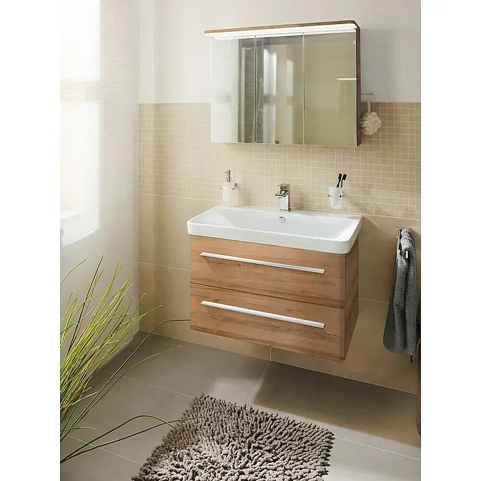Camargue Modern 3.0 Badmöbel-Set MO80B3 - Gesamtbreite Badmöbel: 80 cm, Berg Eiche, Matt, 3 -tlg. - Das Bild zeigt ein modernes Badezimmer mit einem Unterschrankwaschtisch aus Holz und einem Spiegelschrank. Der graue Teppich sorgt für einen angenehmen Kontrast.