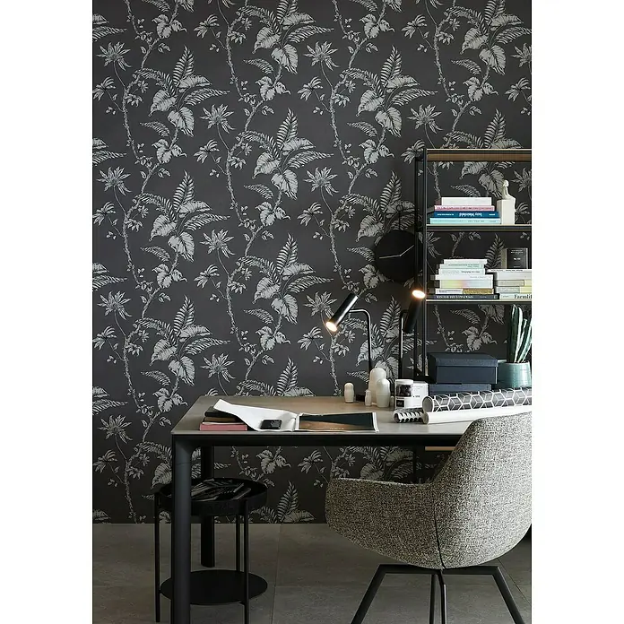 SCHÖNER WOHNEN-Kollektion Vliestapete - Braun/Grau, Floral, 10,05 x 0,53 m - Schreibtisch mit Tischlampe und Bücherregal im Arbeitszimmer mit floraler Tapete. Der Schreibtisch ist mit Büchern und Büromaterial ausgestattet.