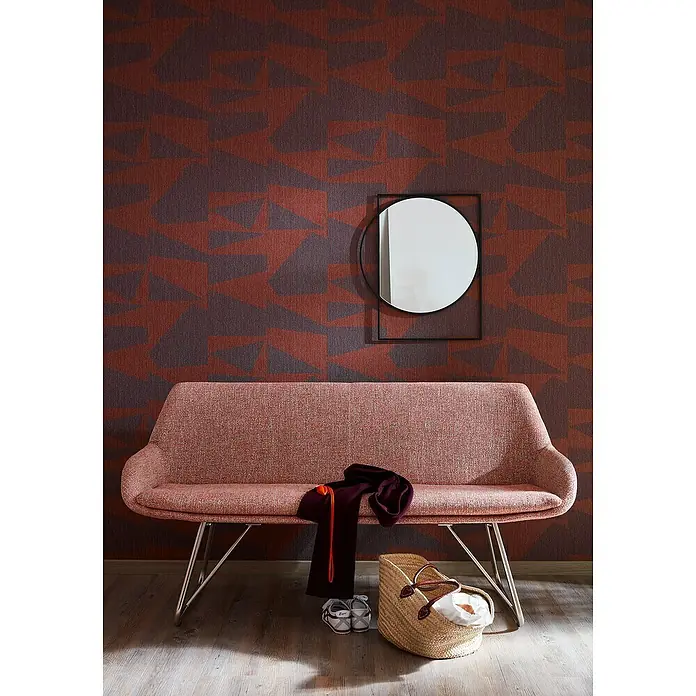 SCHÖNER WOHNEN-Kollektion Vliestapete - Braun/Orange, Grafisch, 10,05 x 0,53 m - Stilvolle Aufnahmeszene mit einem modischen Sofa, einem runden Spiegel und dekorativen Elementen vor einer gemusterten Wand.