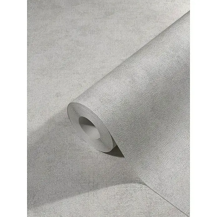 Marburg Sand & Stones Vliestapete Shades - Grauweiß, Uni, 10,05 x 0,53 m - Nahaufnahme einer Rolle hochwertiger, grauer Textiltapete, die eine elegante und moderne Wandgestaltung ermöglicht.
